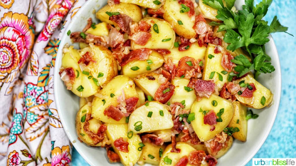 landscape photo of a bowl of baby potato salad with bacon with colorful napkin