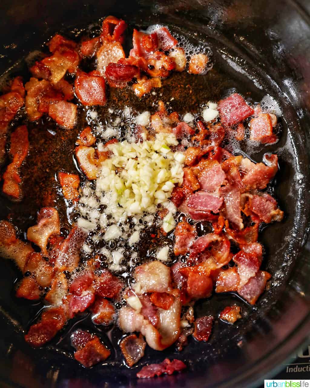 adding garlic to cooked bacon