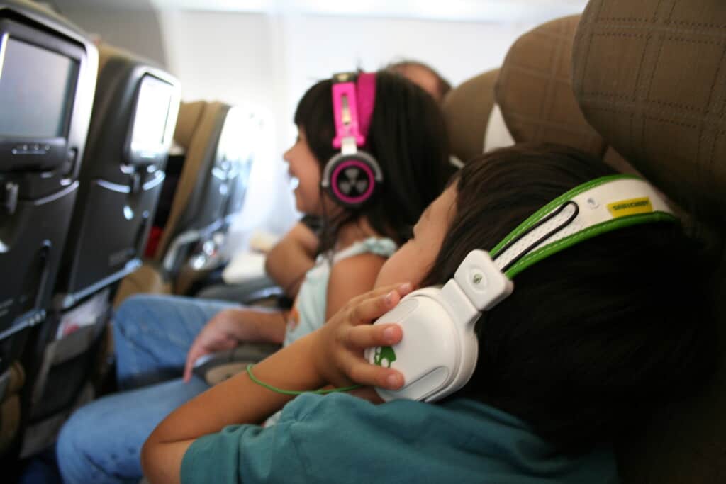 daughter and son on a plane watching tv