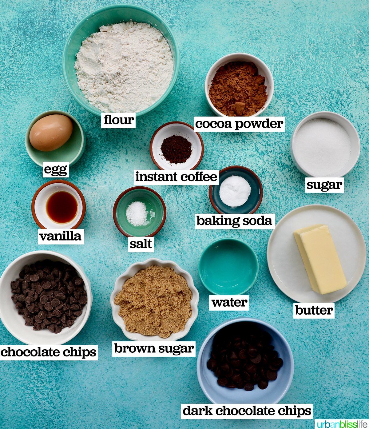bowls of ingredients to make double chocolate coffee cookies on a blue background.