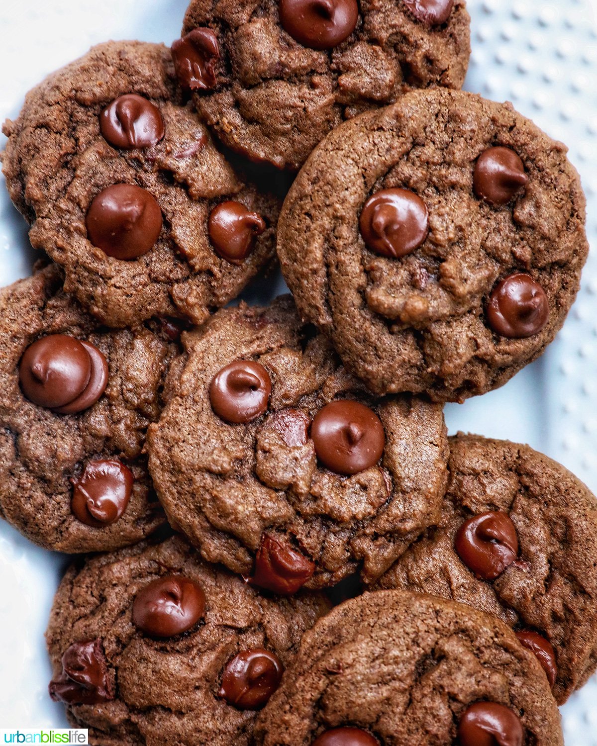 several double chocolate coffee cookies layered on a white plate.