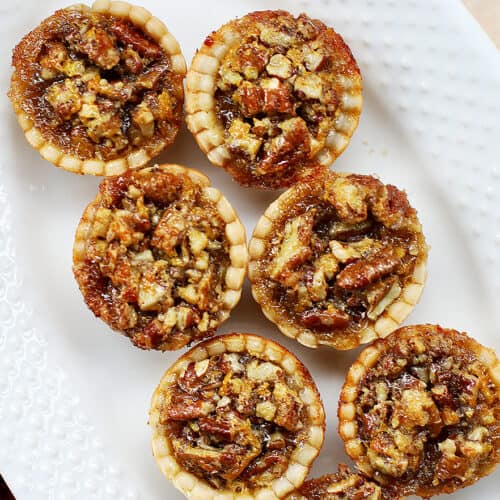 mini pecan pies on a serving platter.