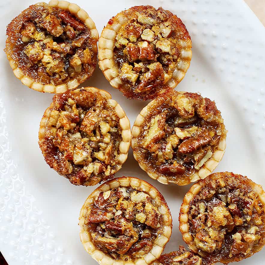mini pecan pies on a serving platter.