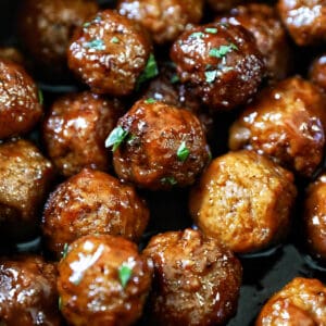 closeup of several slow cooker honey bourbon meatballs on top of each other in a crockpot.