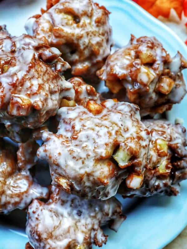 apple fritter donuts stacked on top of each other on a plate.