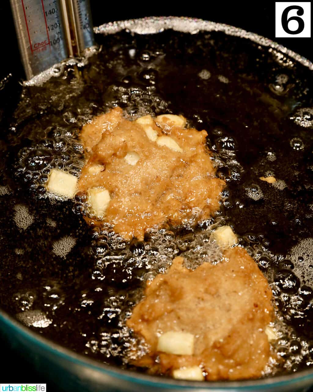 apple fritter donuts frying in a Dutch oven.