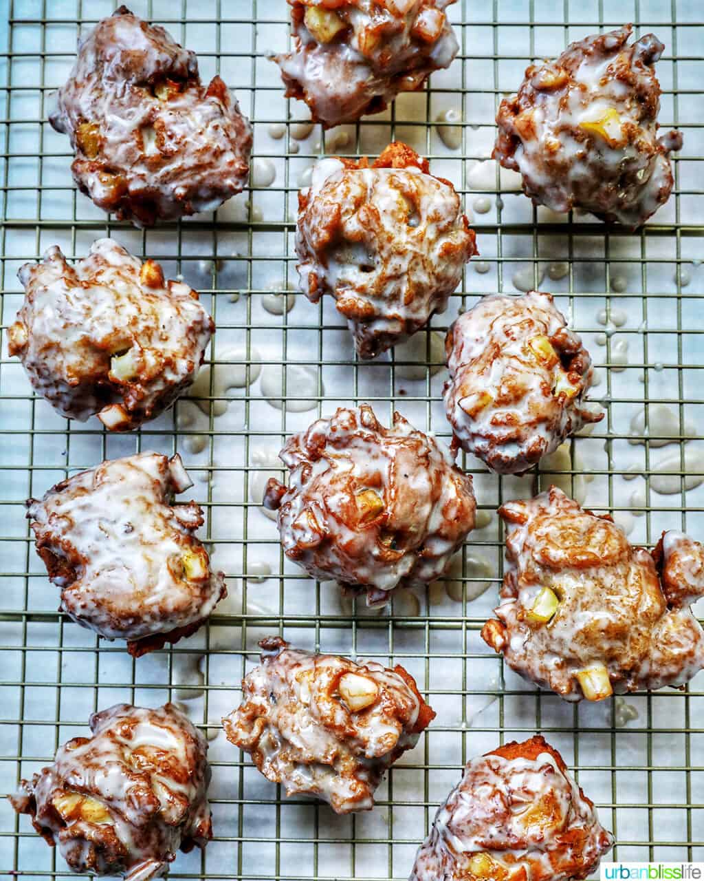 glazed apple fritter donuts on a wire rack.