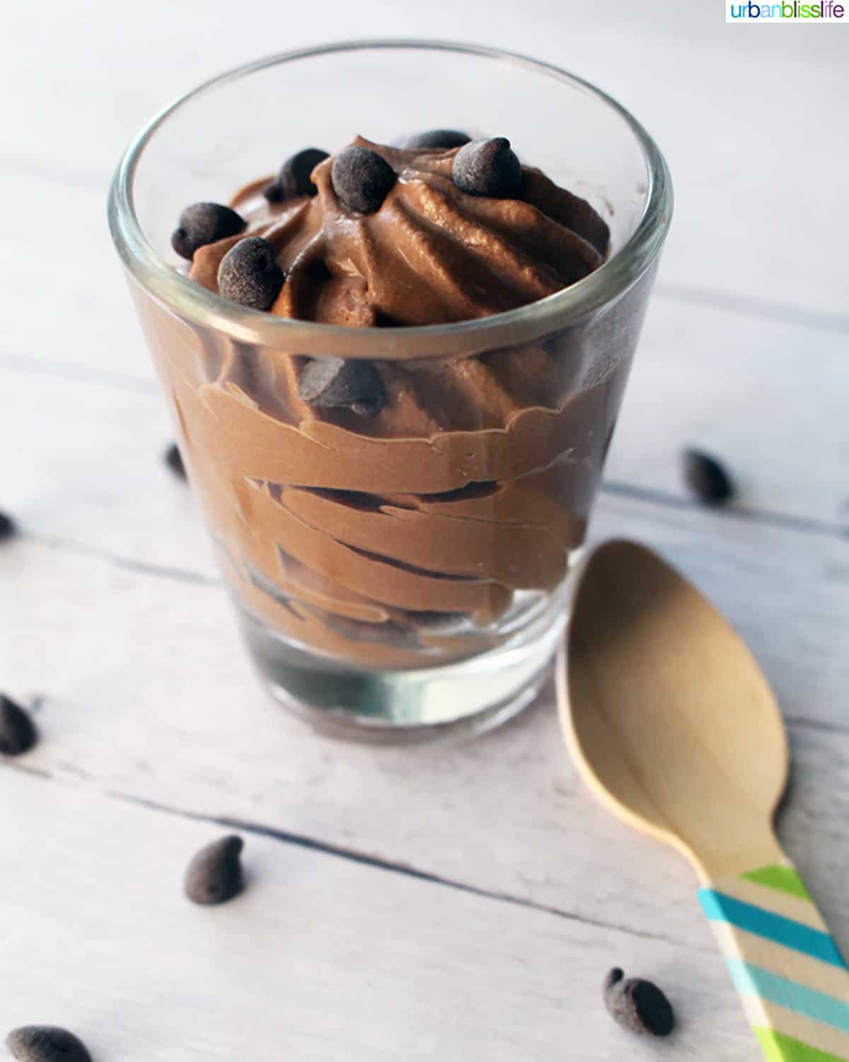 dairy free chocolate mousse in a shot glass with a wooden spoon