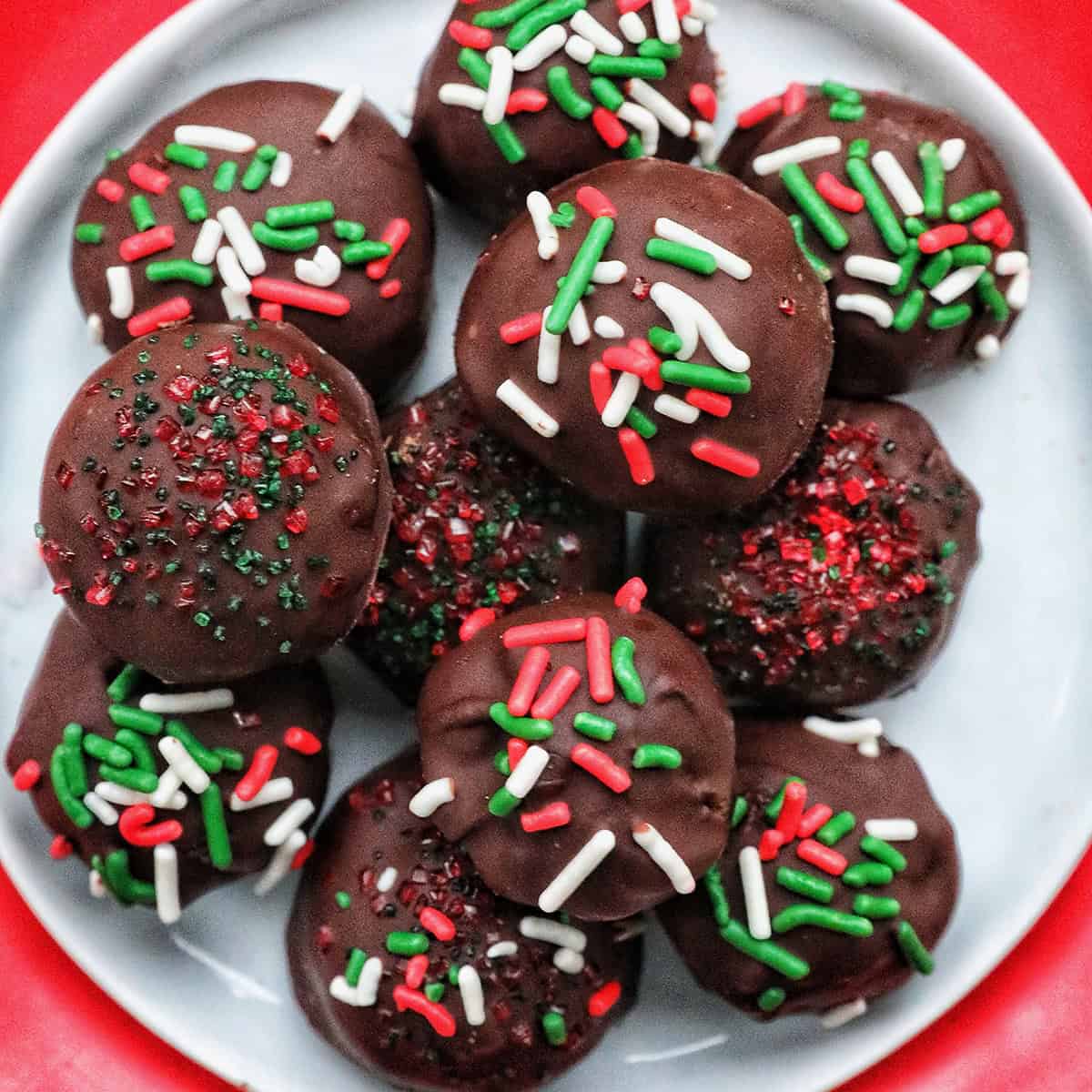 oreo truffles with red, white, and green sprinkles in a Christmas table setting.