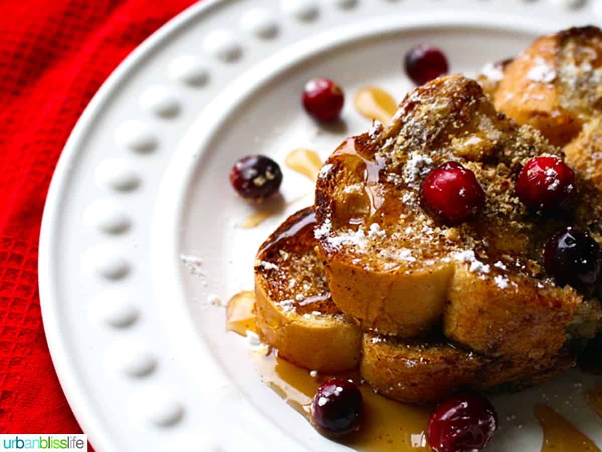 stack of brioche french toast on a white plate with cranberries.