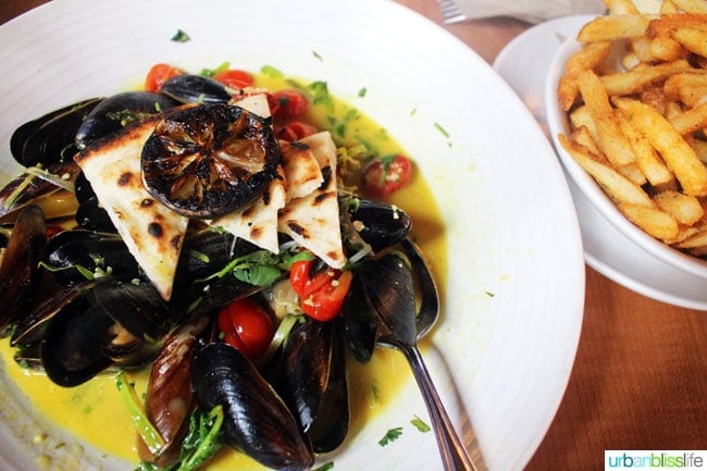 white bowl with mussels and side of fries at Canoe restaurant in victoria BC Canada.