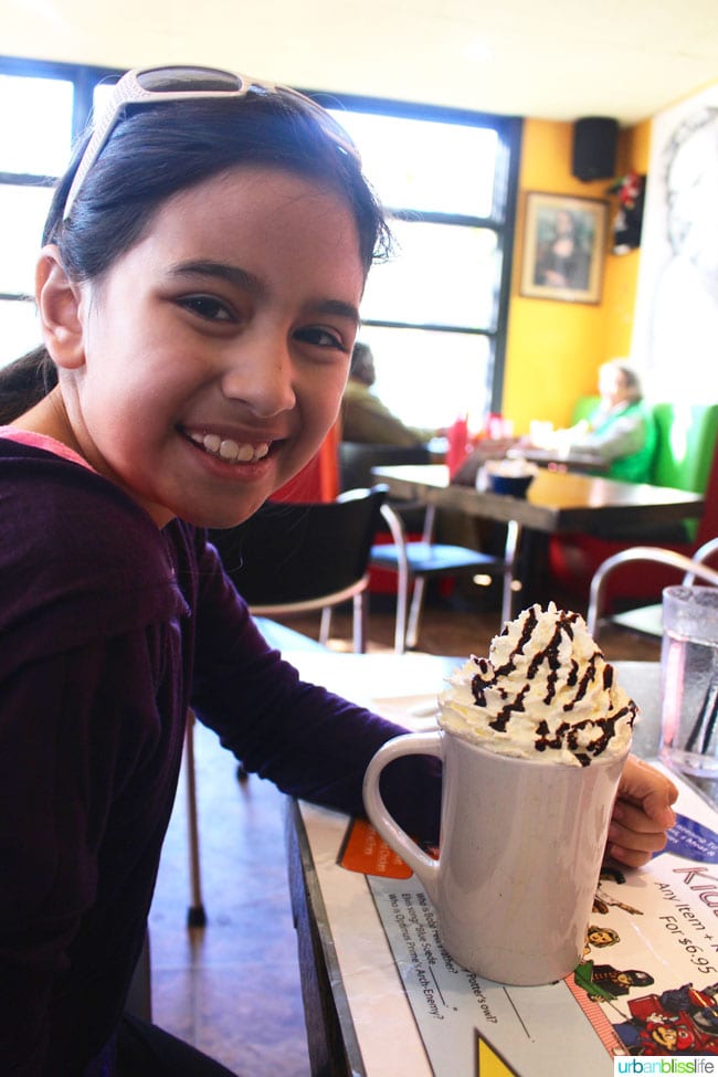 hot chocolate mug topped with a mountain of whipped cream and chocolate sauce drizzle at Floyd's Diner in Victoria British Columbia, Canada.