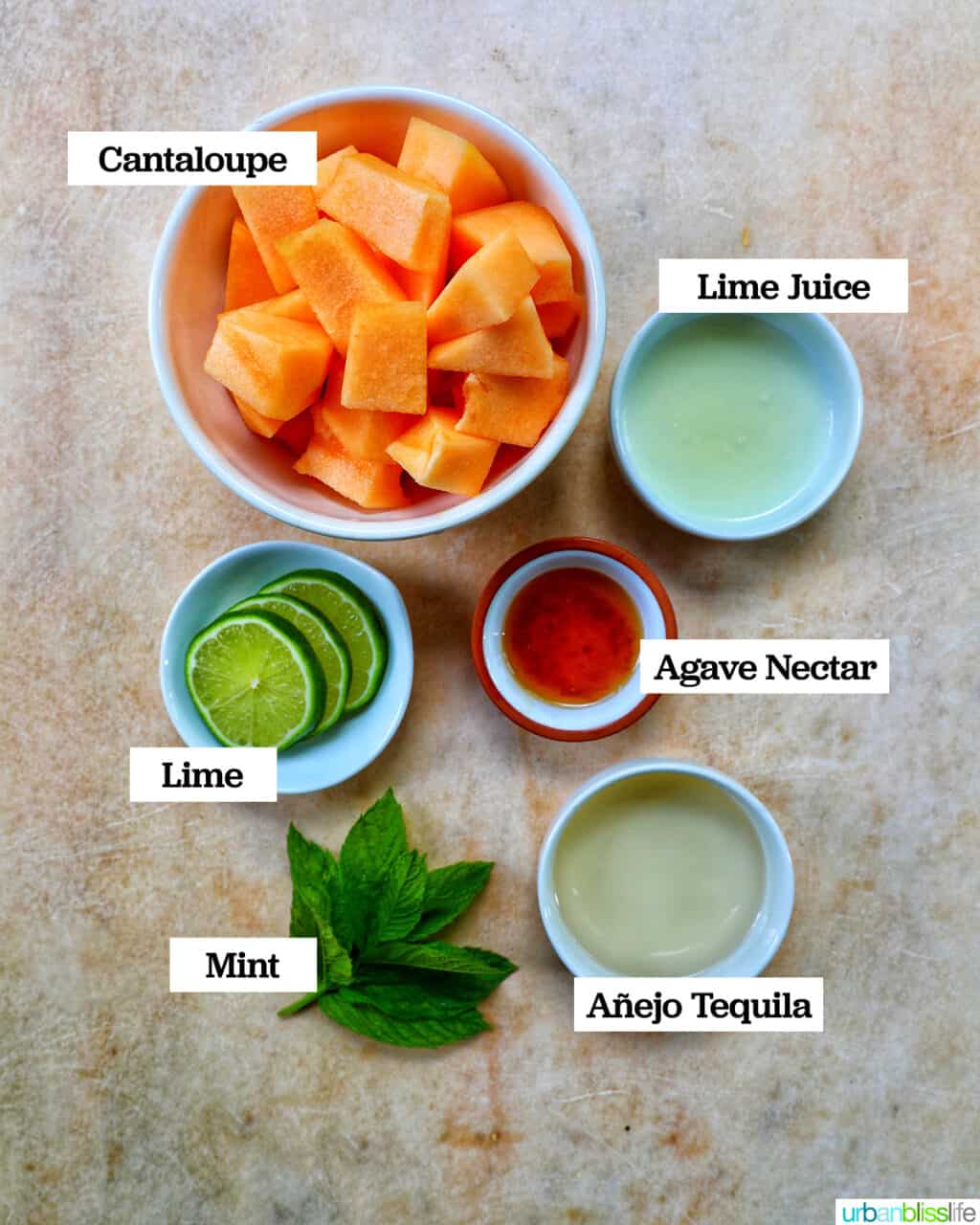 ingredients in bowls to make cantaloupe melon margarita cocktails on a yellow faded background.