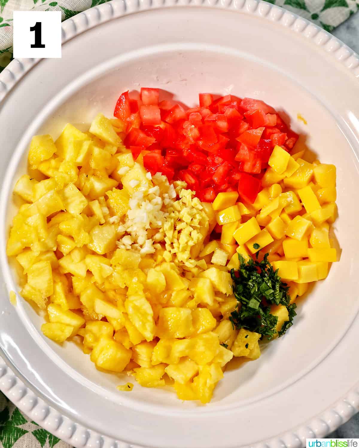 ingredients for pineapple mango salsa in a large white bowl.