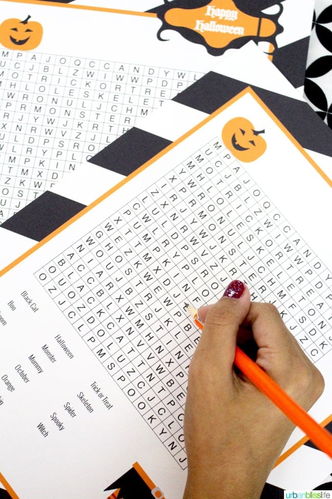 hand with pencil doing a Halloween Word Search