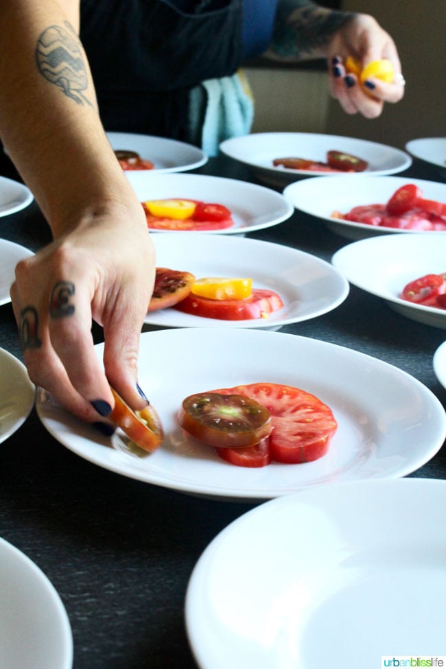 chef plating sliced tomatoes