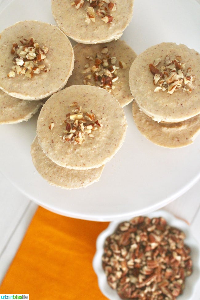 overhead view of the tops of several stacked nutty vegan cheesecake bites with chopped nuts topping.