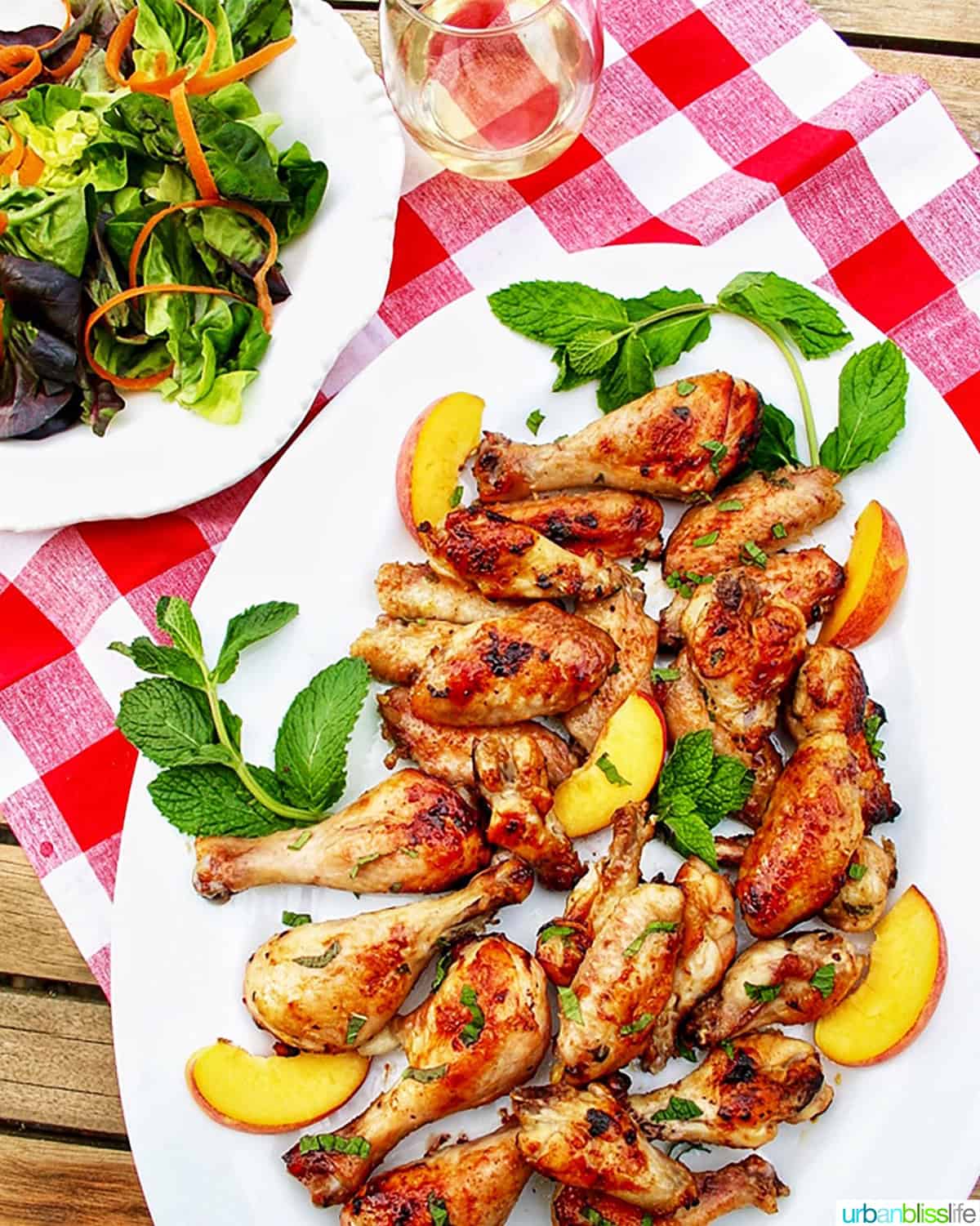 peach bourbon grilled chicken on a white plate with salad.