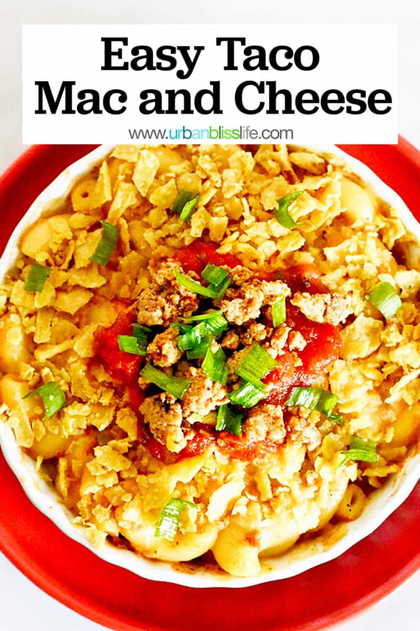 bowl of taco mac and cheese with crushed tortilla chips, tomatoes, and cilantro on an orange plate with title text that reads "Taco Mac and Cheese."