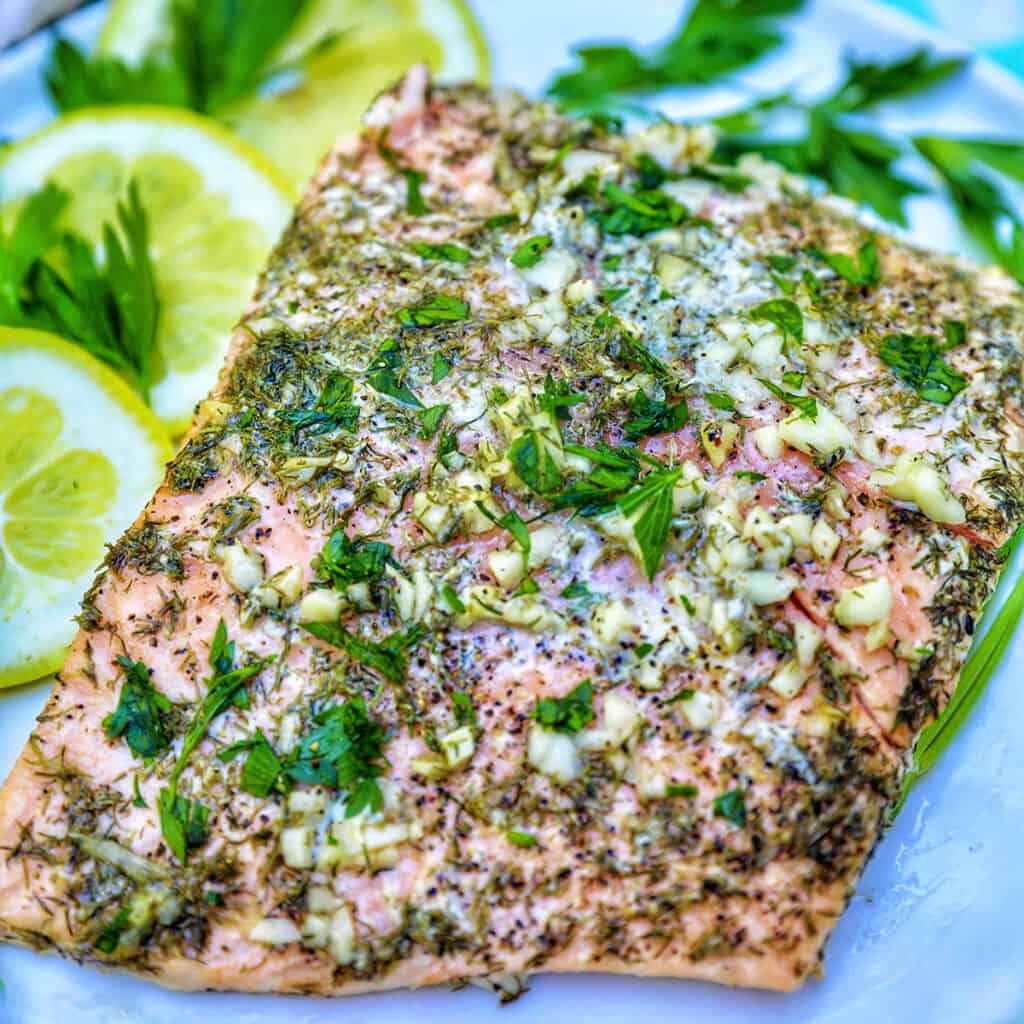 grilled salmon with lemon slices, garlic, and herbs.