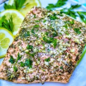 grilled salmon with lemon slices, garlic, and herbs.