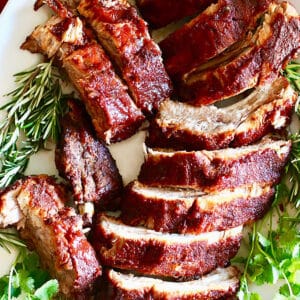 BBQ pork ribs sliced on a plate with herbs