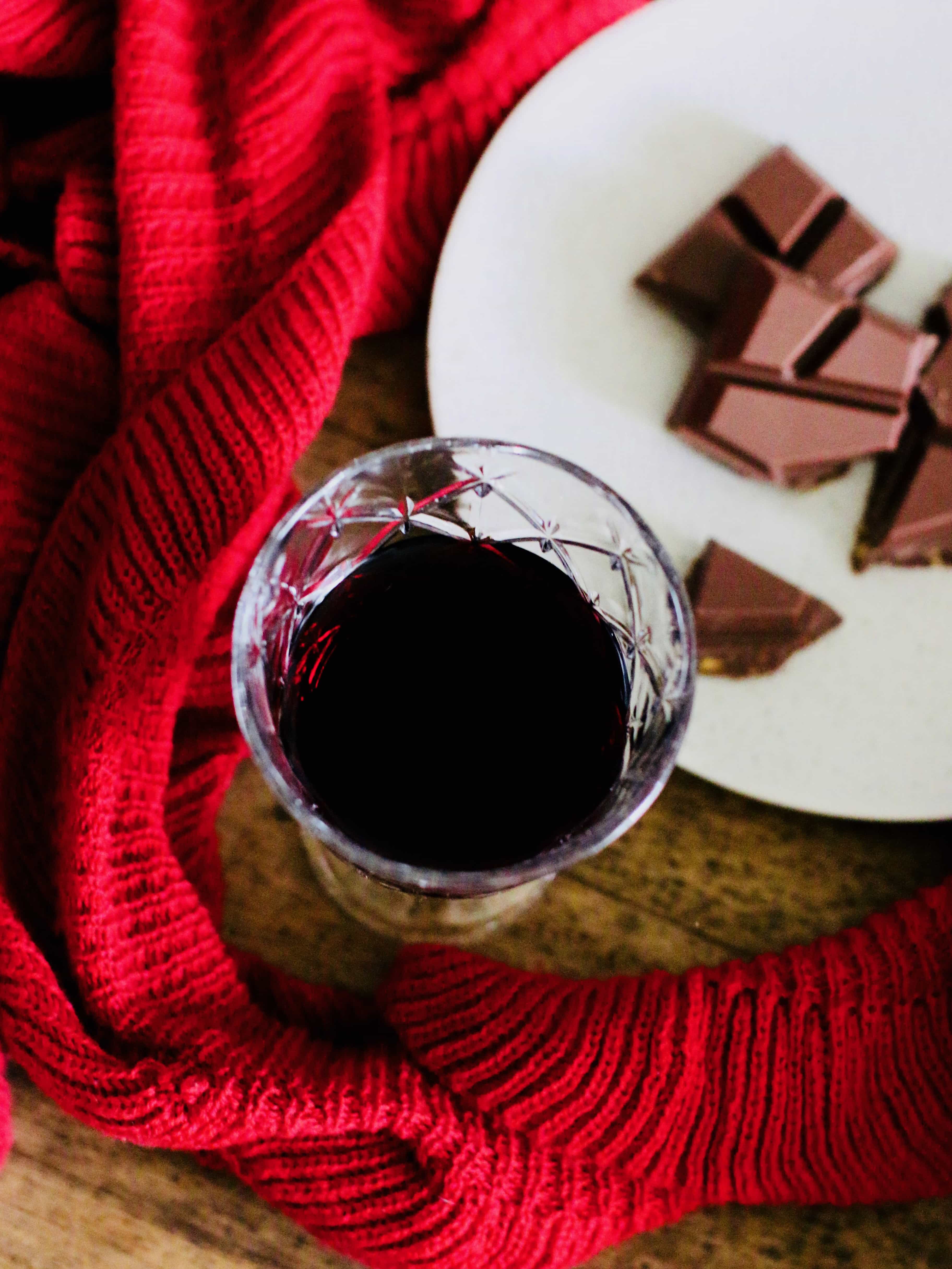 glass of red wine with plate of chopped chocolate