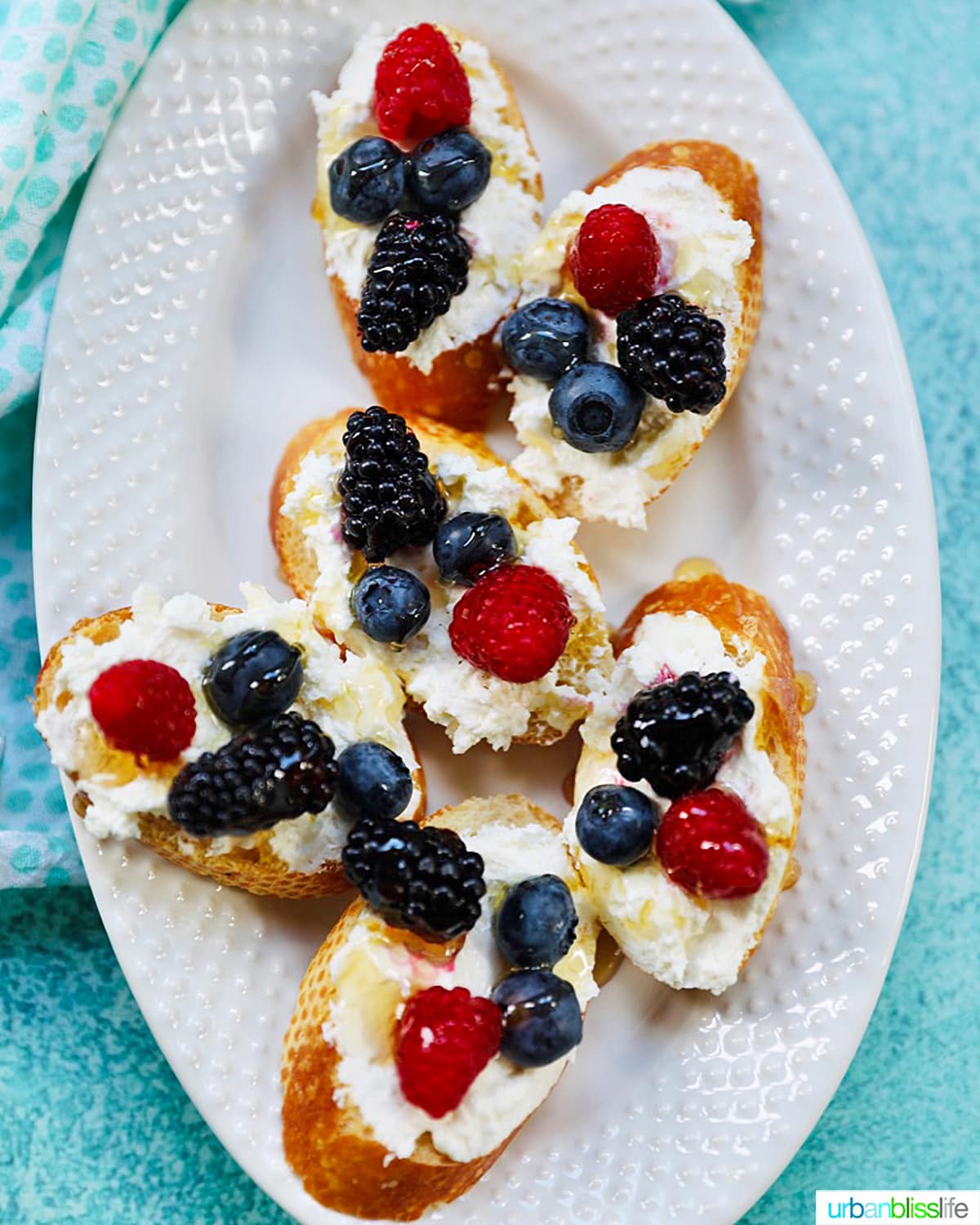 plate full of ricotta crostini with summer berries