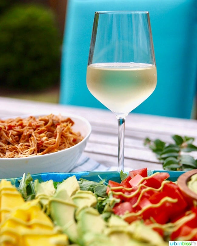 glass of white wine with summer barbecue picnic table