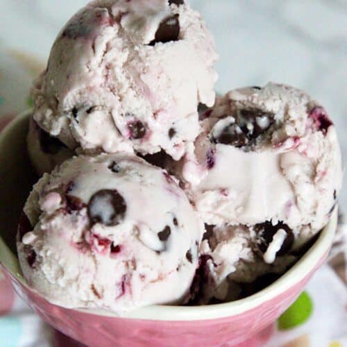 scoops of cherry chocolate chip ice cream in a pink bowl.