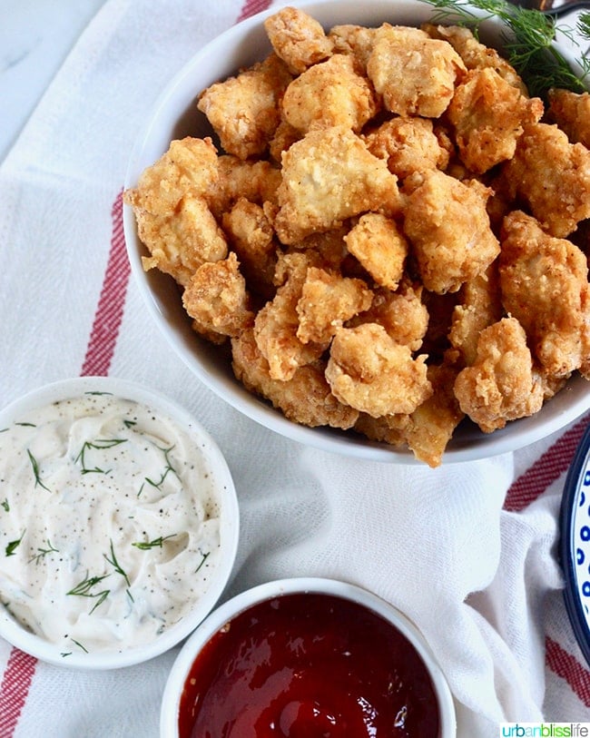 bowl full of crispy Air Fryer Popcorn Chicken with dipping sauces.