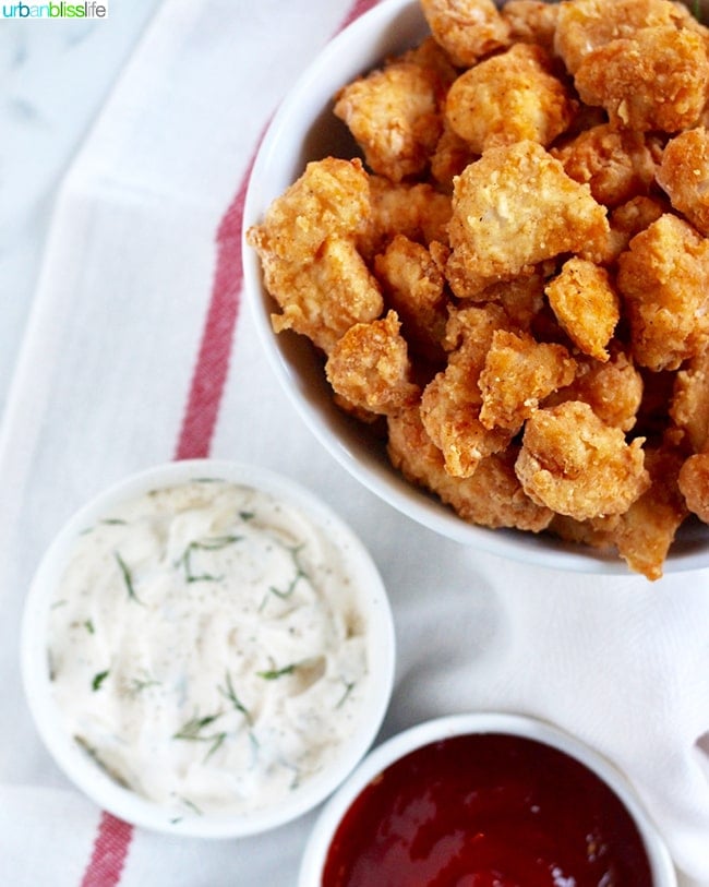 bowl full of crispy Air Fryer Popcorn Chicken with dipping sauces