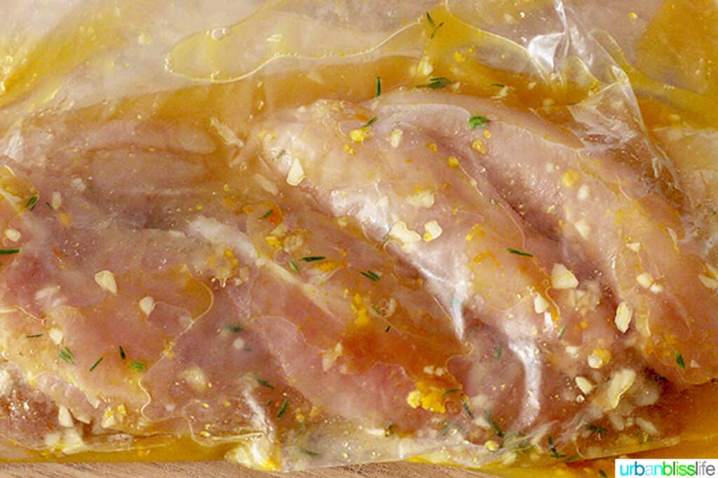 chicken breasts marinating in honey orange sauce in ziplock bags.