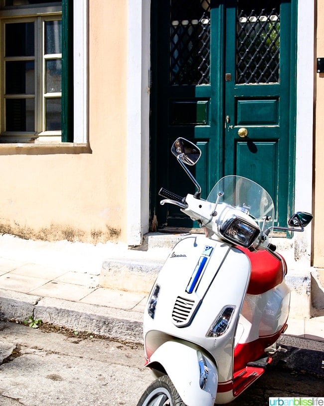 white vespa in front of building with green door in Athens, Greece