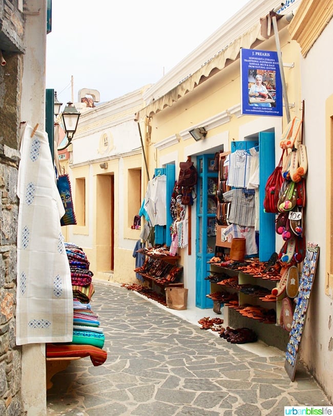 quaint side street with stone road and shop with shoes and bags on Karpathos, Greece.