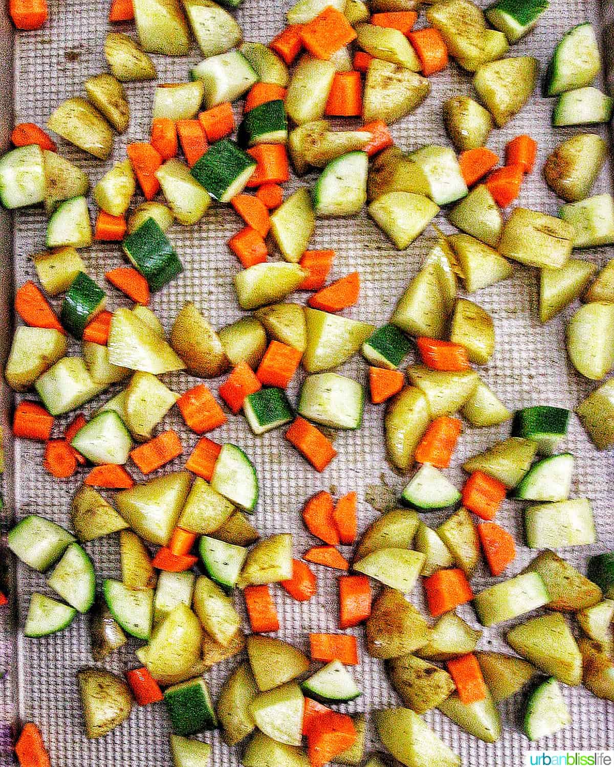 zucchini, potatoes, and carrots on a sheet pan.