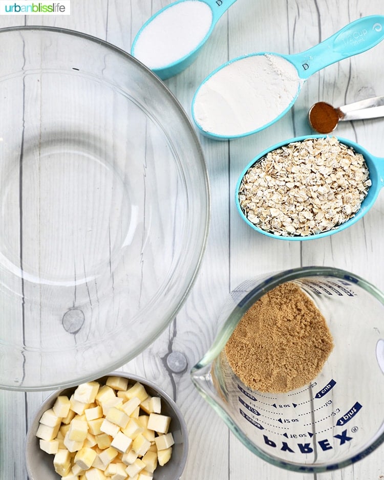 ingredients for apple pie bars in bowls on a white table.