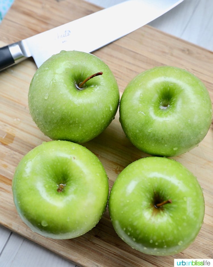 Granny Smith green apples for baking on a cutting board with knife.