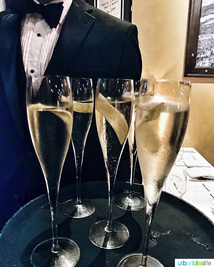 champagne glasses on a tray held by a waiter 