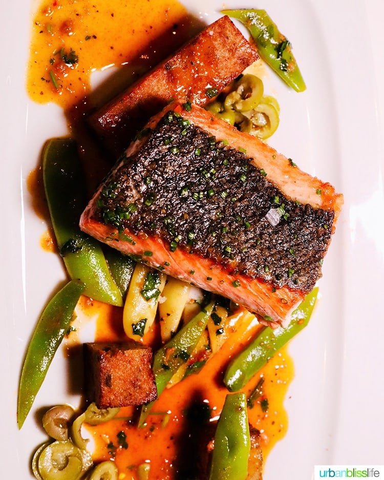 salmon with skin on and vegetables on a plate  at RingSide Steak House in Portland, Oregon.