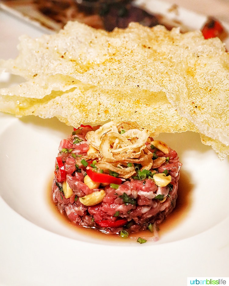 steak tartare with crispy chips on the side of a white plate  at RingSide Steak House in Portland, Oregon.
