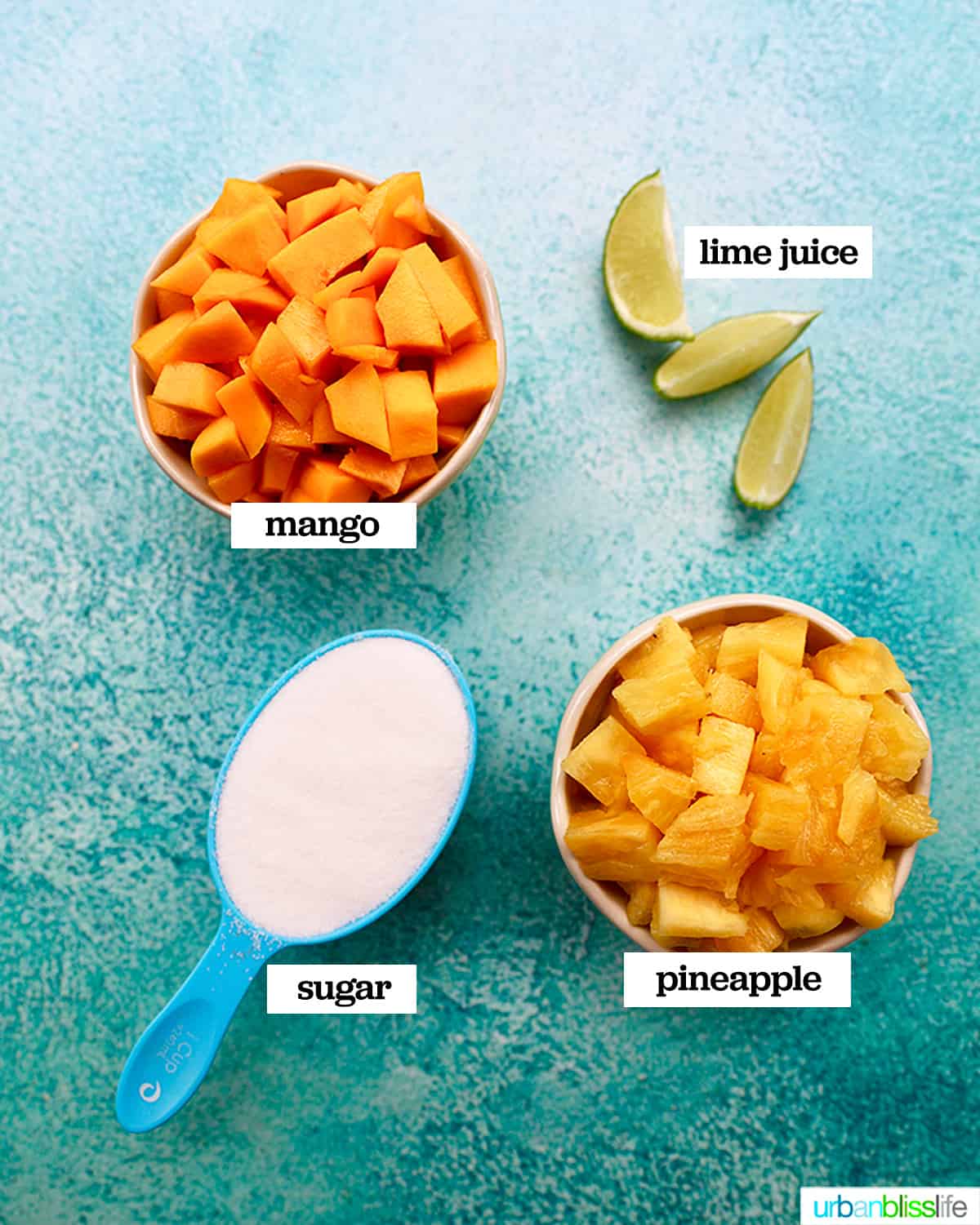 bowls of four ingredients to make pineapple mango sorbet on a bright blue background.