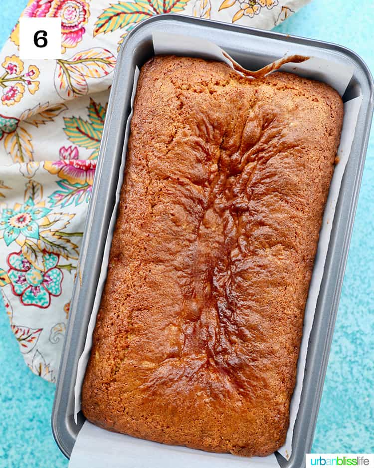 pineapple bread freshly baked in a loaf pan on blue background with a colorful floral napkin.