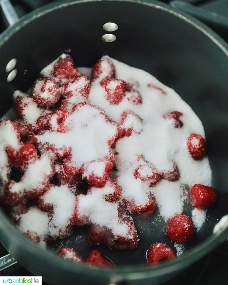 making raspberry jam: raspberries and sugar in saucepan