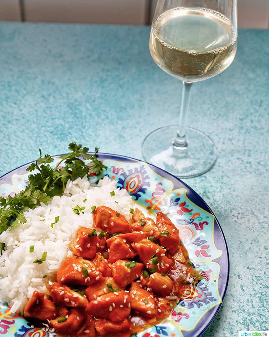 plate of Instant Pot Honey Garlic Chicken and rice with glass of white wine