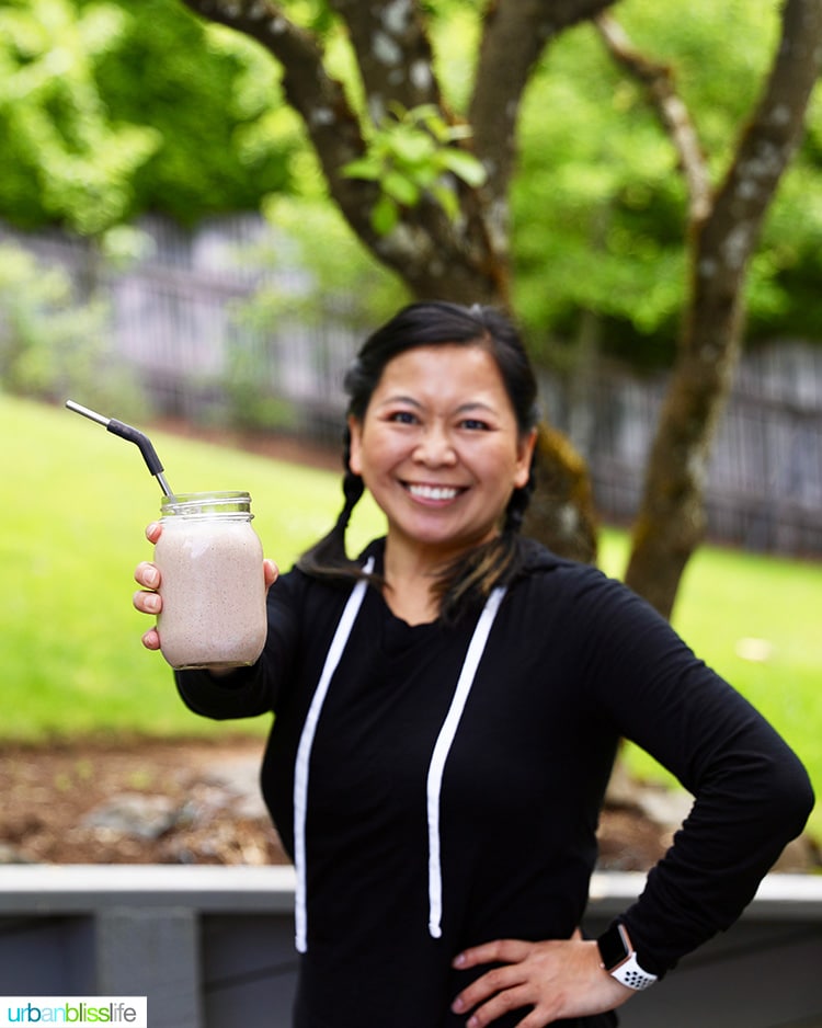 Marlynn holding a glass of chocolate post-workout protein shake