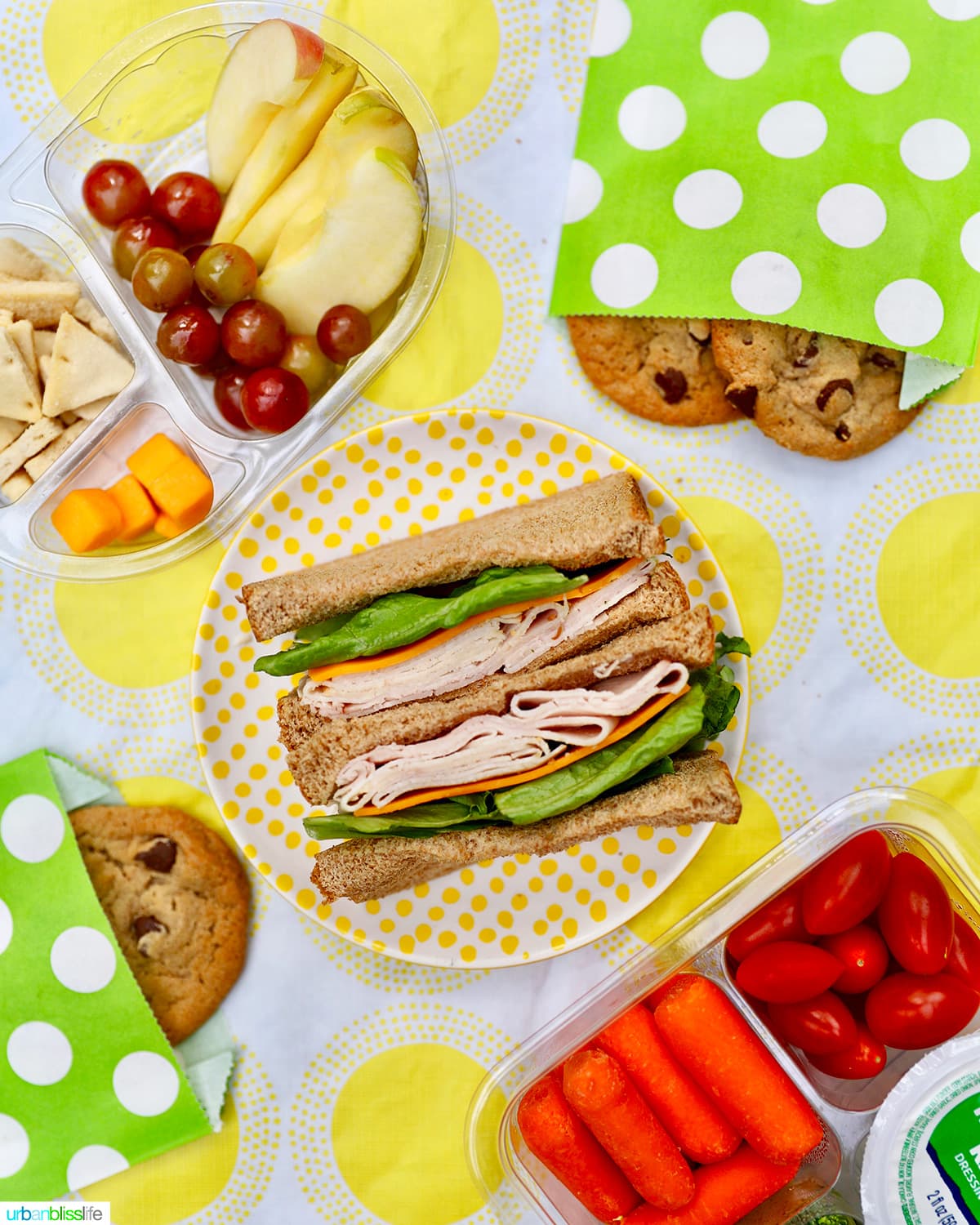 back to school lunches - sandwiches, cookies, cheeese, fruit, vegetables against yellow and white tablecloth