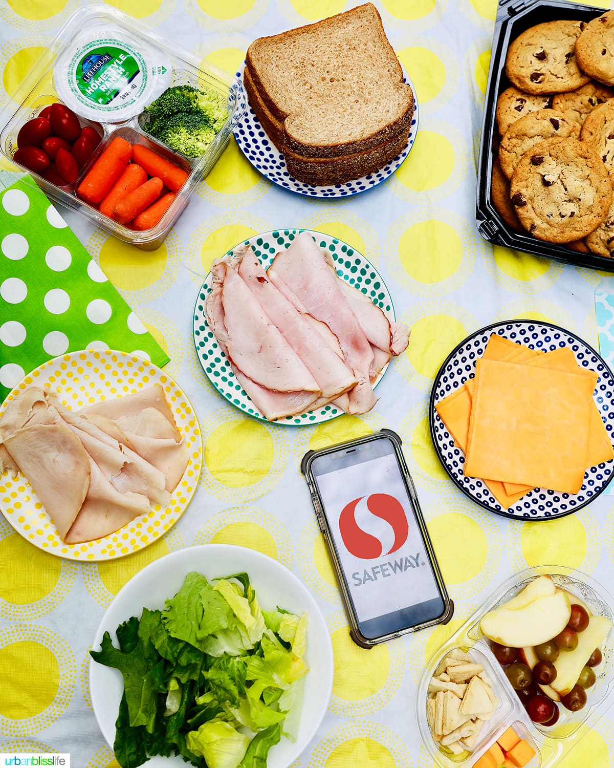 back to school lunches - sandwiches, cookies, cheeese, fruit, vegetables against yellow and white tablecloth