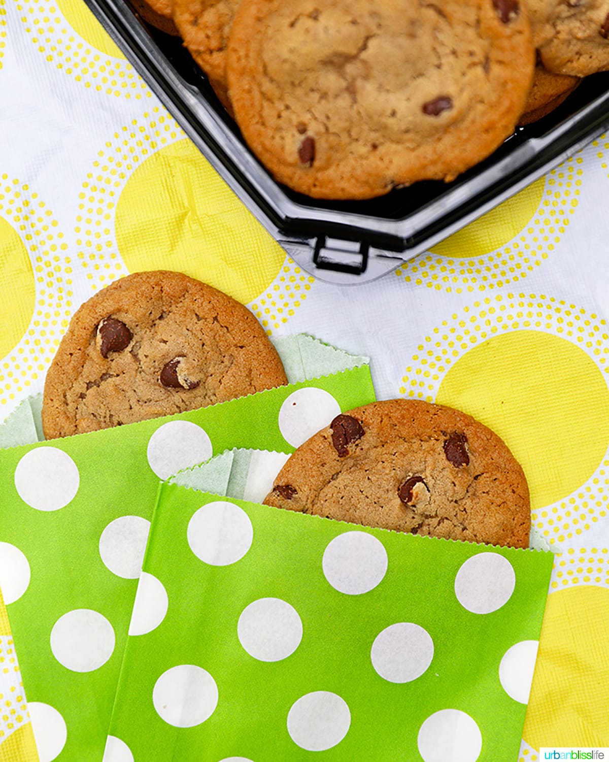 chocolate chip cookies in cute bright green paper sleeves against yellow and white tablecloth