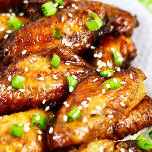 baked teriyaki chicken wings with sesame seeds and sliced green onions.